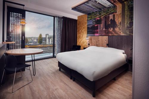 乌得勒支Inntel Hotels Utrecht Centre的一间卧室配有一张床、一张桌子和一个窗户。