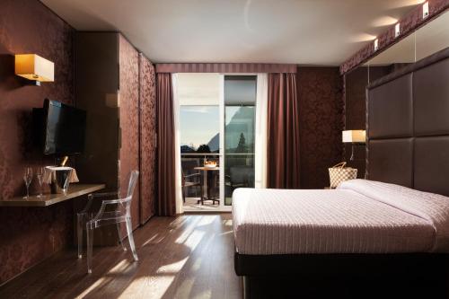 加尔达湖滨托奈利克里斯塔尔皇宫酒店的酒店客房设有一张床,享有阳台的景色
