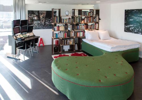 阿姆斯特丹SWEETS - Sluis Haveneiland的一间卧室配有绿色的床、一张书桌和一个图书馆