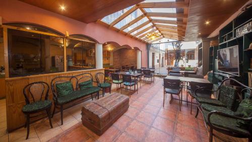库斯科MOAF Cusco Boutique Hotel的一间在房间内配有桌椅的餐厅