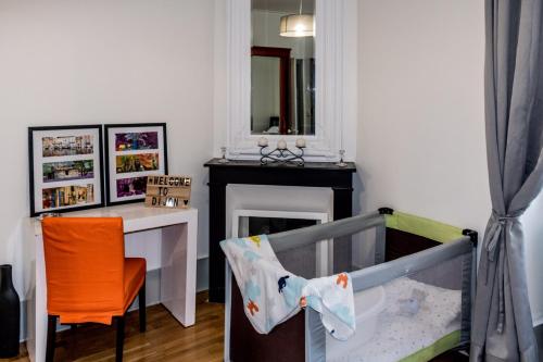 第戎La ptite chouette的一间设有婴儿床、桌子和椅子的房间