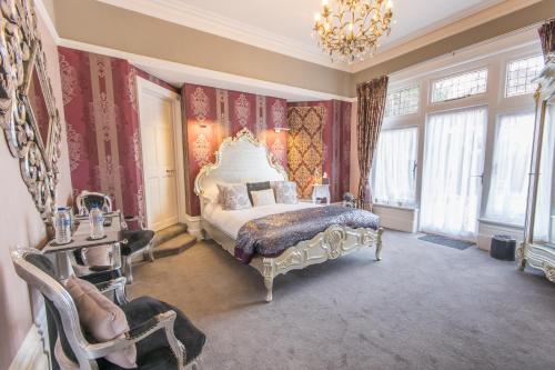 浦耳格洛菲尔德庄园酒店的一间卧室配有一张特大号床和吊灯。