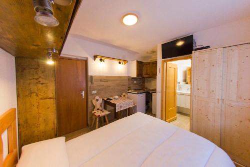 坎皮泰洛CasaMau Studio的一间带白色大床的卧室和一间厨房