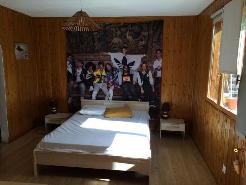 拉卡诺chez steph&aurore的卧室配有一张床,墙上有一群人