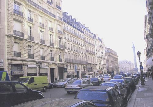 巴黎LOUVRE VENDOME with air conditionning的一条繁忙的城市街道,汽车停在大楼旁边