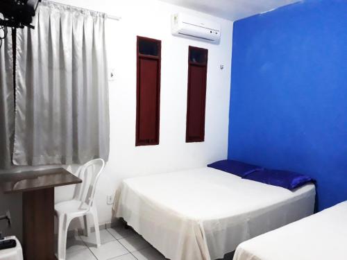 巴纳伊巴Pousada Lunar的一间设有两张床和蓝色墙壁的客房