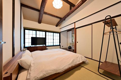 京都竹屋西阵豪华町屋的一间卧室配有一张大床和一台平面电视