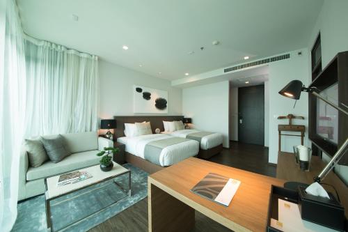 曼谷城市地平线酒店的客厅配有床和沙发