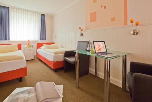 汉堡考克斯伽尼酒店的酒店的客房配有一张带笔记本电脑的书桌