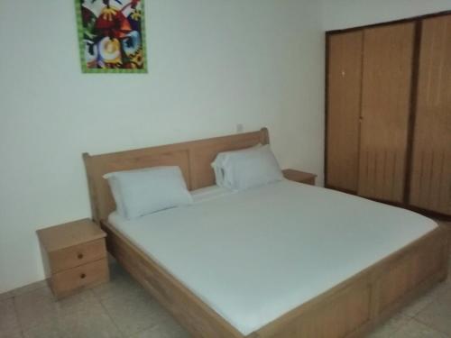 Oko SomboPANAASA GUEST HOUSE的一间卧室配有一张带木制床头板的床