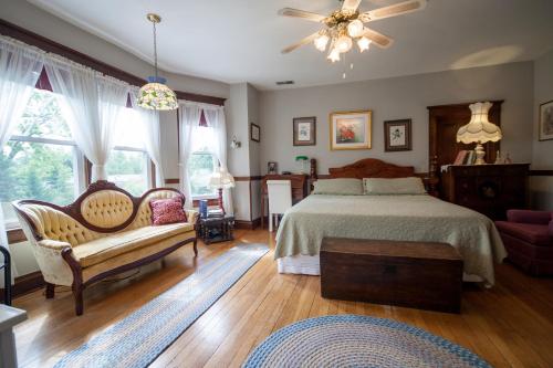 哈里森堡Friendly City Inn B&B的一间卧室配有一张床、一张沙发和窗户。