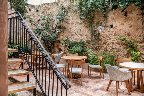 干尼亚奥夫酒店的一个带桌椅的庭院和一面墙