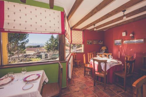 Barajas de GredosHotel Rural La Dehesilla的餐厅设有两张桌子和大窗户