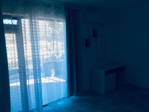 基尔科沃Апартаменти Романтика Кирково的黑暗的客房设有窗户、窗帘和桌子