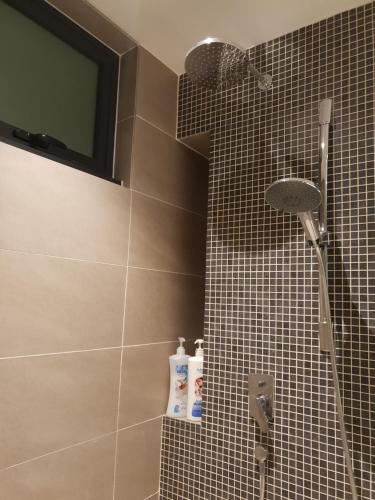 吉隆坡Sunway Velocity V Residence Suites的带淋浴的浴室以及墙上的电视。