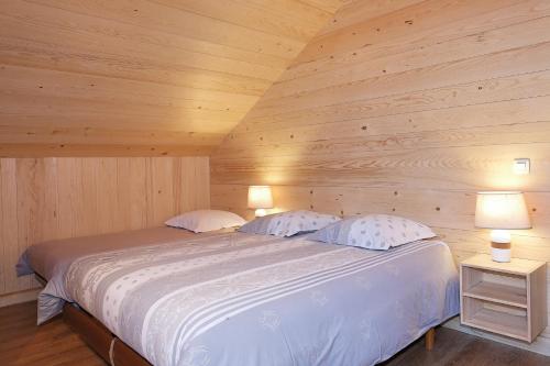 科尔顿Le Refuge的木间内的一张床位,配有两盏灯