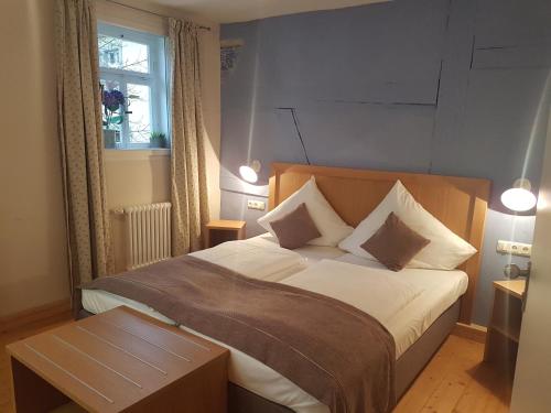 诺德海姆市场Wirtshaus am Markt的一间卧室配有一张带白色床单和一张桌子的床。
