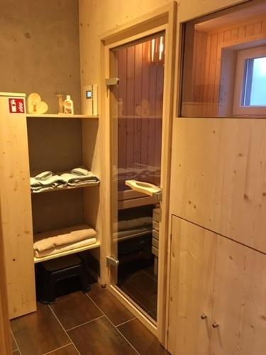 布莱特瑙Chalet Breitnauschön的浴室设有玻璃门,通往带毛巾的衣柜