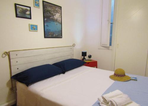 新福卡Casa vacanza Poesia的卧室配有白色的床和帽子