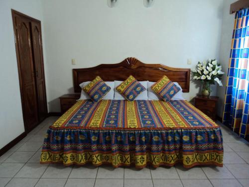 翡翠海岸Canadian Resort Veracruz的床上有色彩缤纷的毯子和枕头