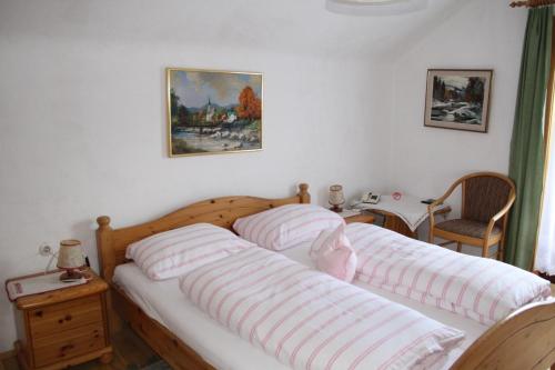 奥西亚歇尔湖畔施泰因多夫沃尔夫旅馆的一间卧室配有两张床,上面有条纹枕头