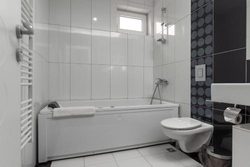 斯科普里多尔西国际酒店的白色的浴室设有浴缸和卫生间。