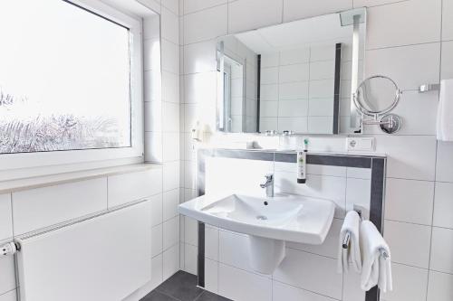 埃姆斯代滕Hotel & Restaurant Pötter的白色的浴室设有水槽和镜子
