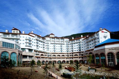 MungyeongSTX Resort的一座白色的大建筑,背景是一座山