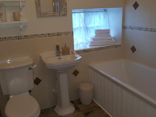 惠特比Underhill Holidays - Underhill Holiday Cottage的浴室配有卫生间、盥洗盆和浴缸。