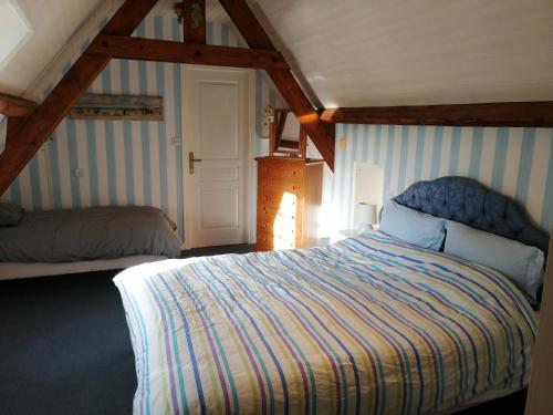 LongueilLe Moulin de Longueil的阁楼上的卧室配有一张大床