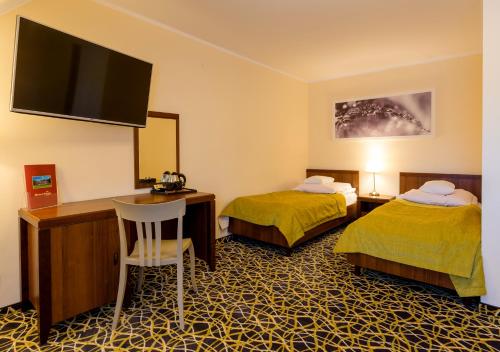 卡尔帕奇雷拉克斯康体SPA酒店的酒店客房设有两张床、一张桌子和一台电视。