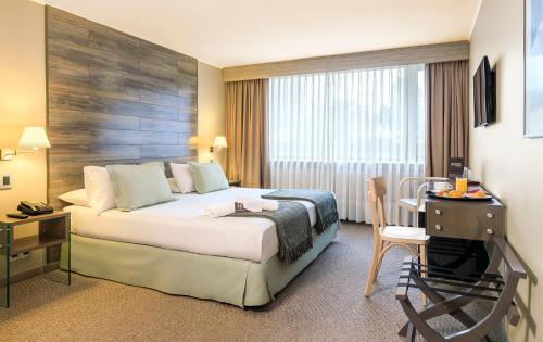 特木科福隆特拉广场酒店的酒店客房配有一张床铺、一张桌子和一张书桌。