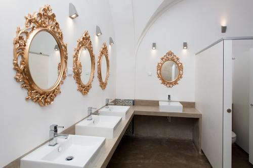 里斯本里斯本落英旅舍的浴室设有3个水槽和墙上的镜子