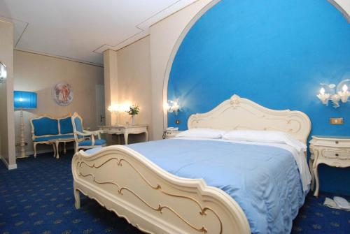 米拉伊尔博其罗酒店的一间卧室设有一张蓝色墙壁的大床