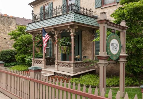 CedarburgWashington House Inn的一座带围栏和美洲国旗的房子