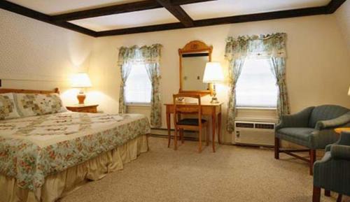 北康威旧场大楼酒店的一间卧室配有一张床、一张桌子和一把椅子
