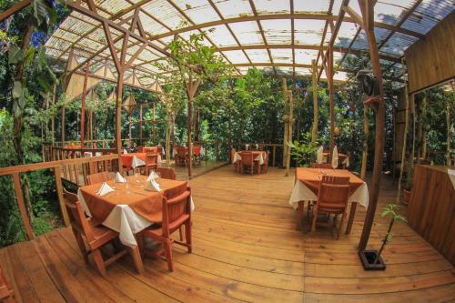 图里亚尔瓦Hotel Wagelia Espino Blanco的木甲板上设有桌椅的餐厅