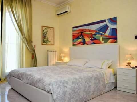 San DonaciB&B Caravaggio的卧室配有一张床,墙上挂有绘画作品