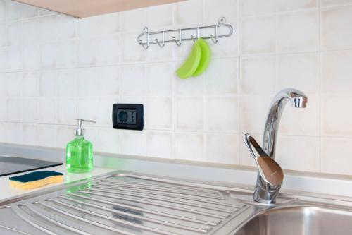 里米尼希格诺公寓酒店的厨房水槽设有水龙头和绿色香蕉