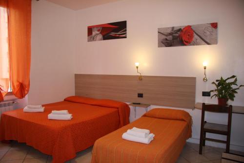 米兰阿德奇酒店的配有橙色床单的客房内的两张床