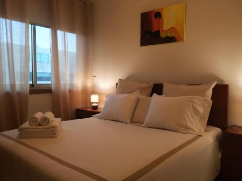 莱萨·达·帕尔梅拉Love Sea Apartment的卧室配有一张大白色床和窗户