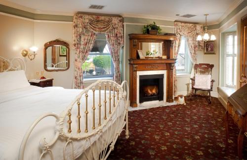 纽波特海滩Doryman's Oceanfront Inn的一间卧室配有一张床和一个壁炉