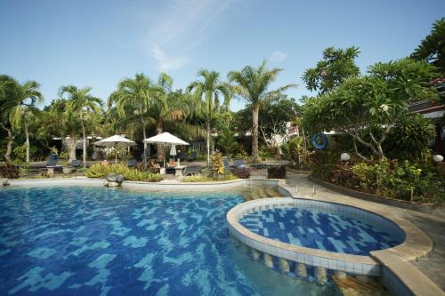 沙努尔斯瓦提卡别墅酒店的棕榈树度假村的游泳池