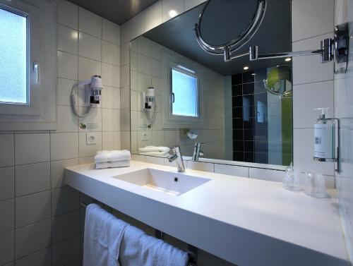 尚贝里新科海博中心酒店的白色的浴室设有水槽和镜子