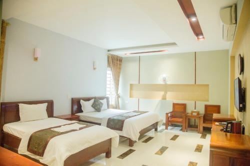 老街市Khách Sạn Hoàng Gia Lào Cai - Hoang Gia Hotel的酒店客房设有两张床和电视。