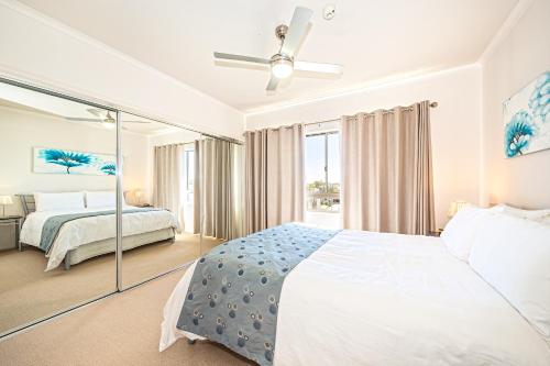 邦加里海湾公寓式酒店的卧室设有一张白色大床和一扇窗户。