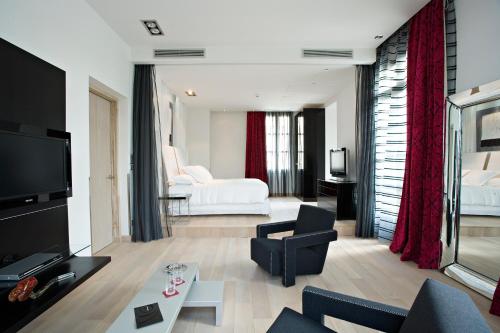 蒙彼利埃Domaine de Verchant & Spa - Relais & Châteaux的带沙发的客厅和带沙发床的房间