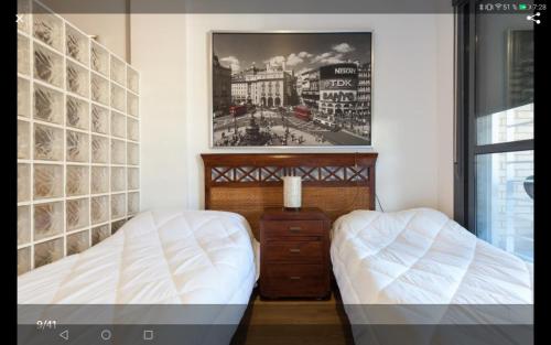 滨海罗克塔斯Calle Austria的卧室配有两张床,墙上挂着一幅画