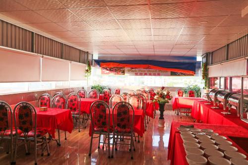 芽庄Khách Sạn Flower Sky Nha Trang的一间设有红色桌椅的用餐室