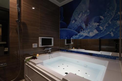 大阪Hotel ZEN Sennichimae (Adult Only)的带电视的浴室设有大浴缸